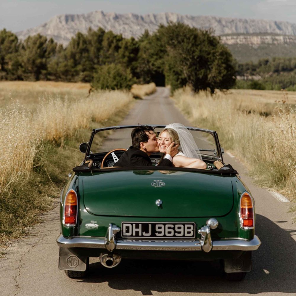 The newlyweds in a convertible, Mont Sainte-Victoire in the distance