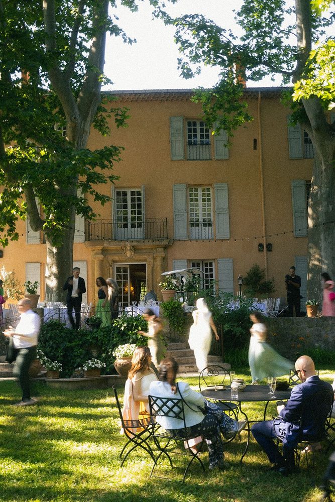 Guests at cocktail hour on the lawn, before the façade