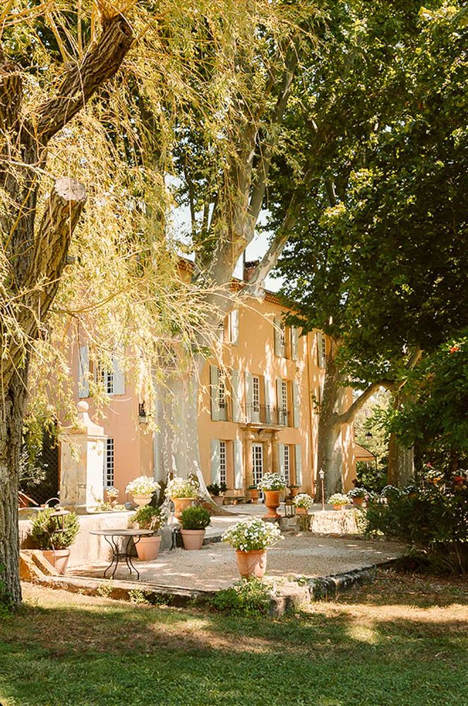 The bastide façade seen through the park trees