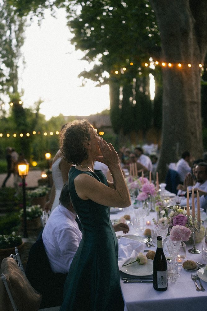 A guest cheers the newlyweds at dusk