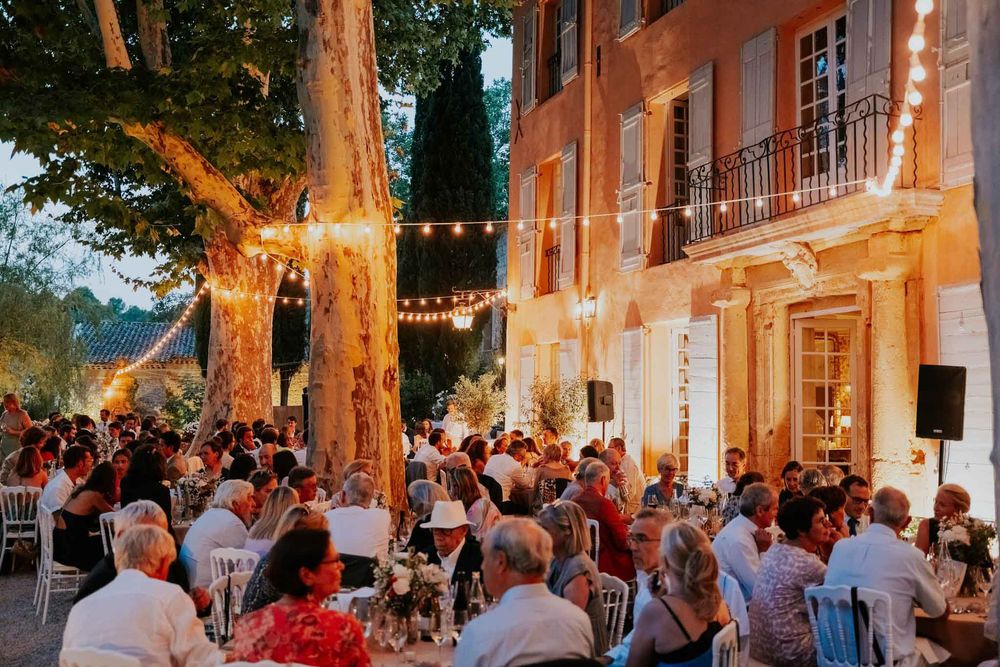 Dinner under string lights at the foot of the façade