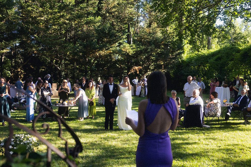 A speech for the newlyweds, among the guests on the lawn
