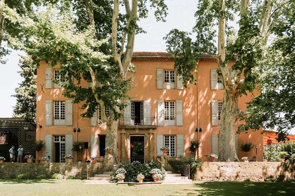 The ochre façade of the bastide, between century-old plane trees