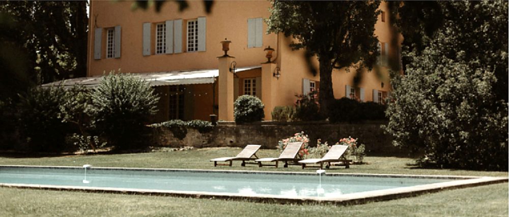 Sun loungers by the pool, the bastide behind the trees
