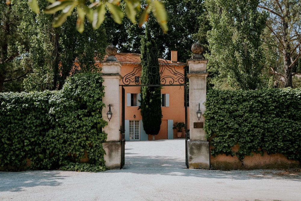 The wrought-iron gate open onto the ochre façade and its shutters
