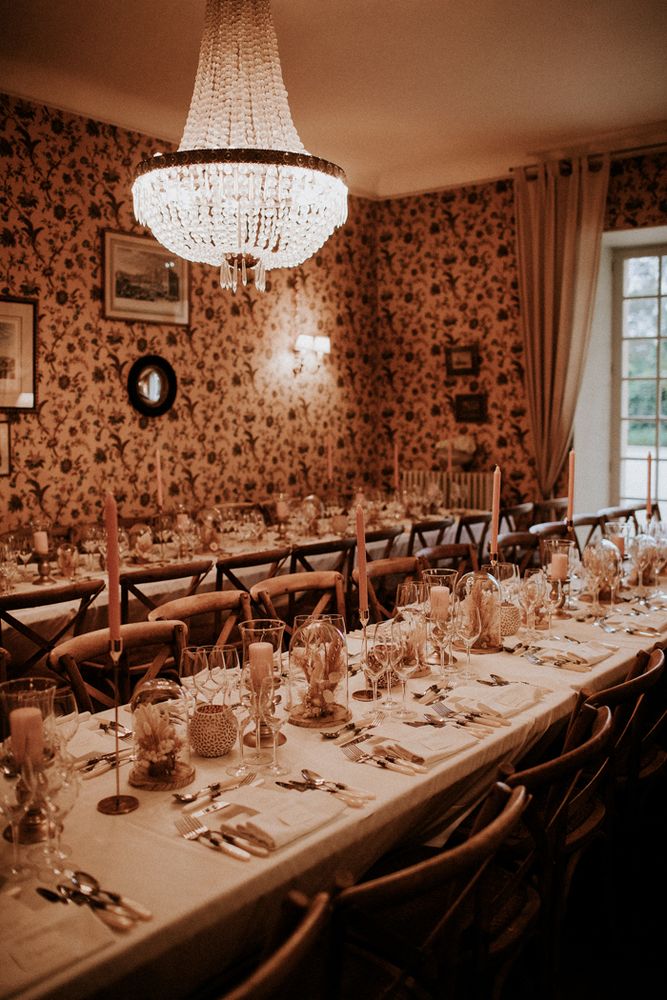 The salon laid for dinner, beneath the chandelier
